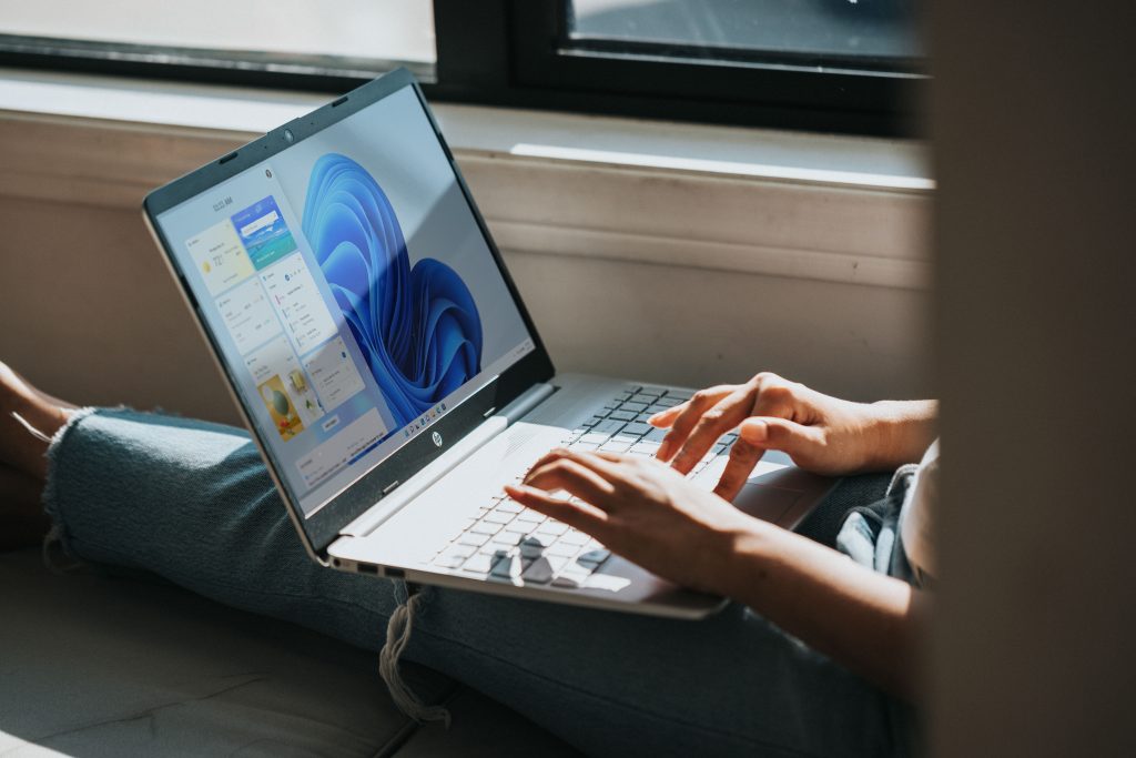 Fingers operating Windows 11 laptop